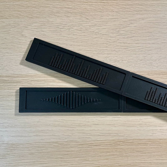 Black deluxe backspacers with the EQ and Sound Wave designs displayed on top of a white oak IKEA Kallax shelf.