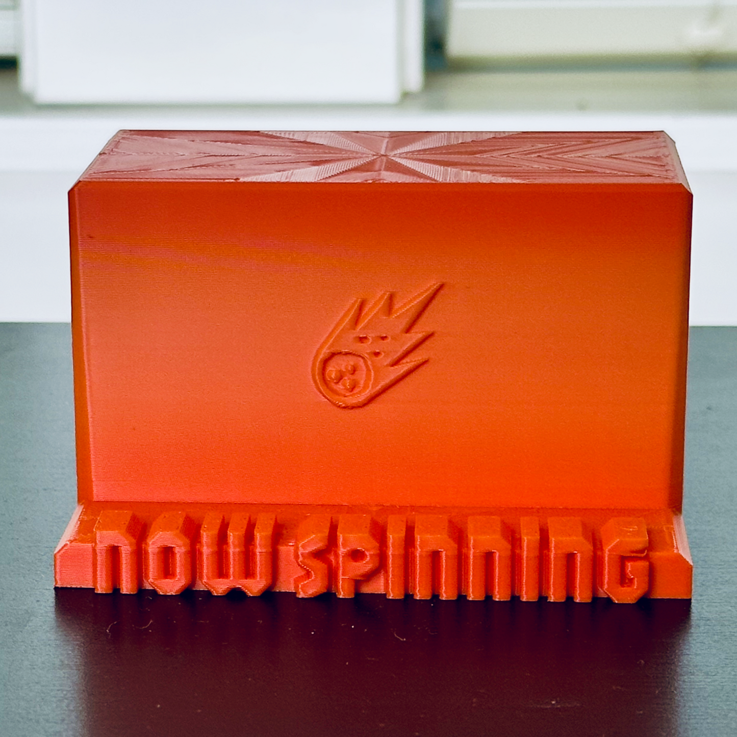 Standalone view of the orange "Now Spinning" display stand.
