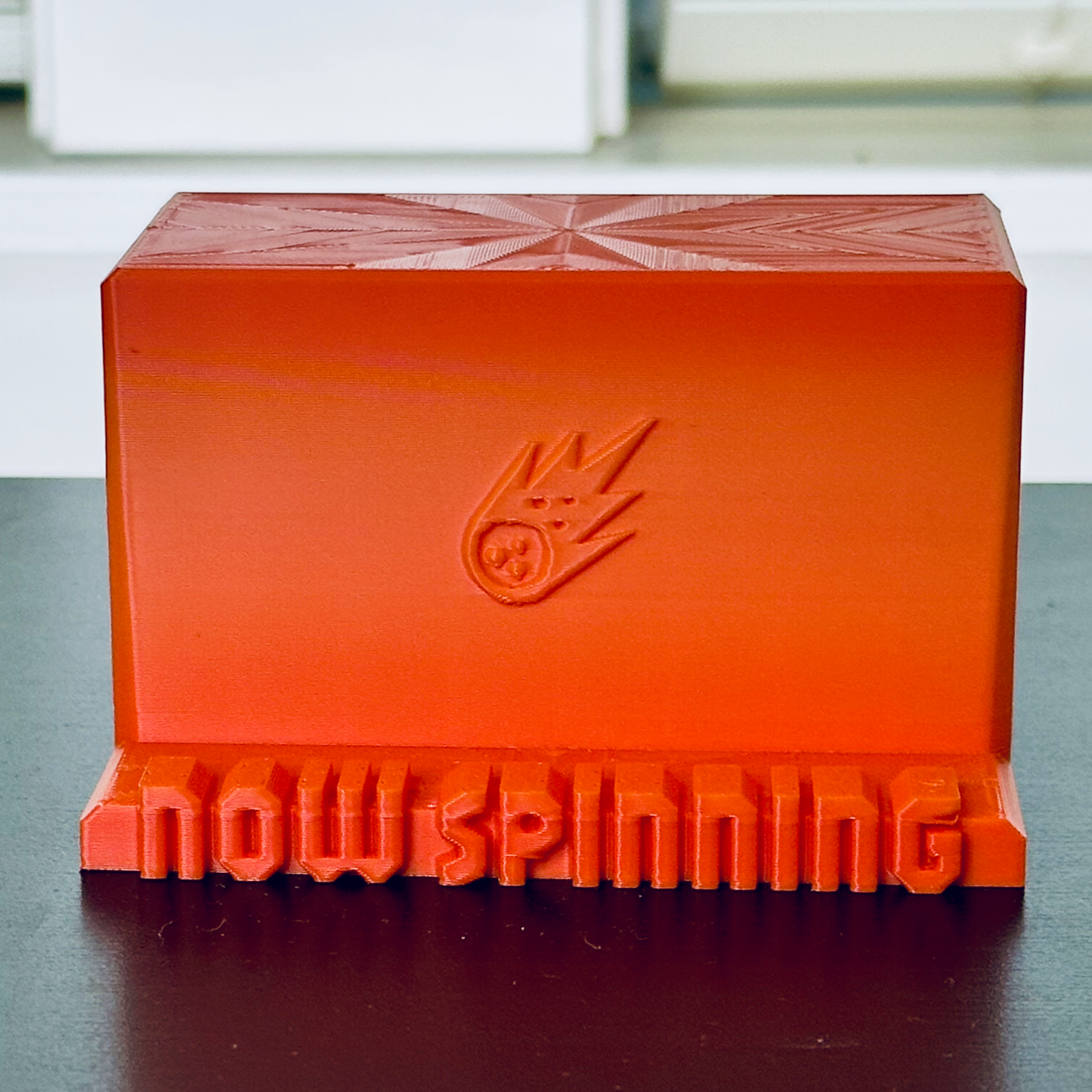 Standalone view of the orange "Now Spinning" display stand.