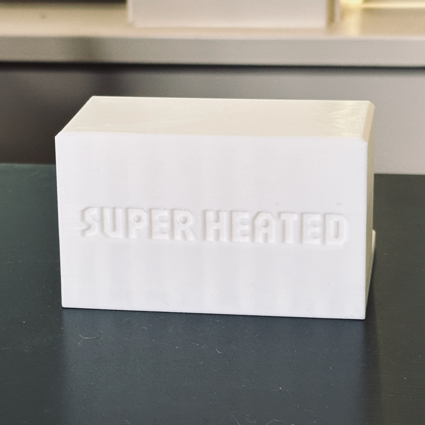 Rear view of the white record display stand with "Super Heated" embossed in it.