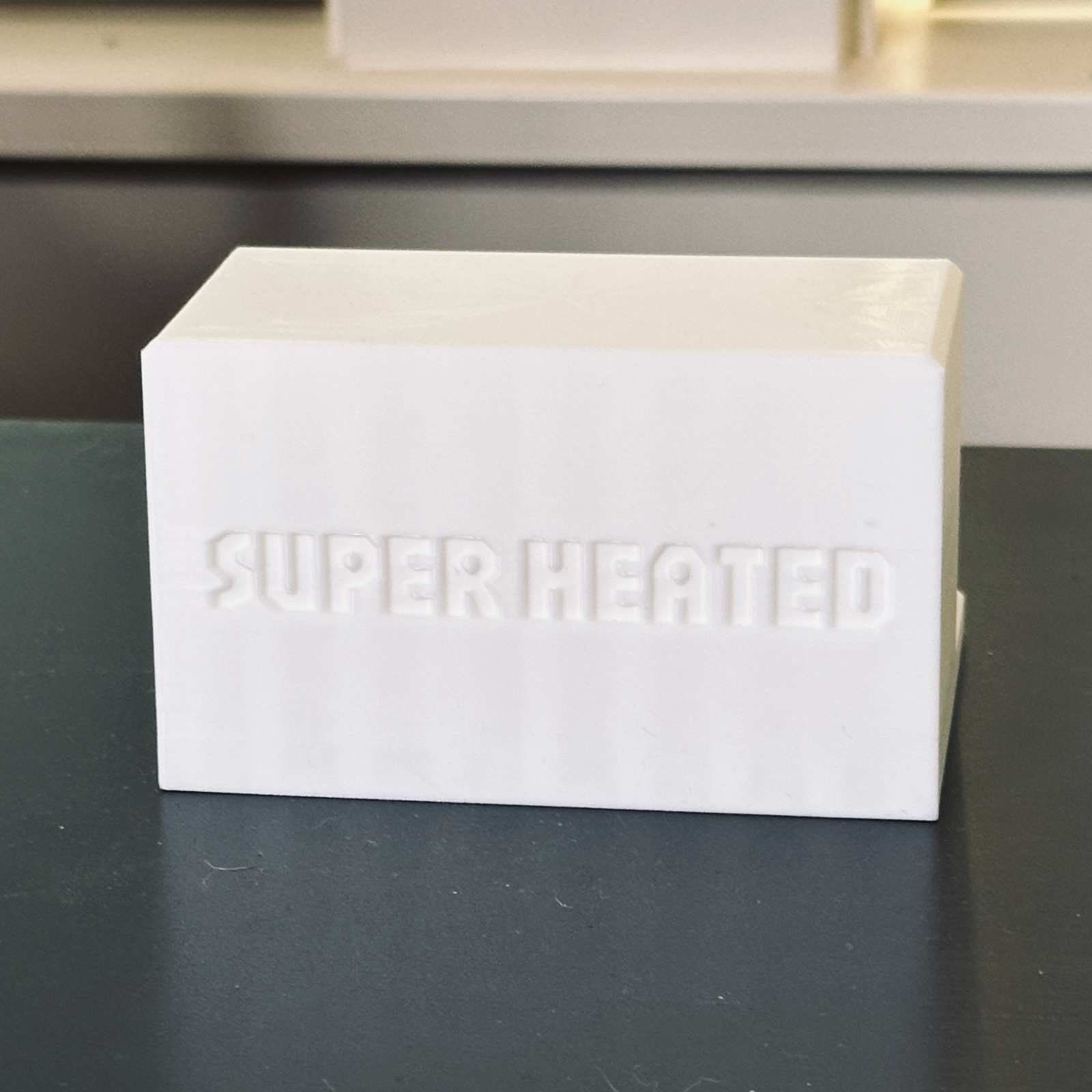 Rear view of the white record display stand with "Super Heated" embossed in it.
