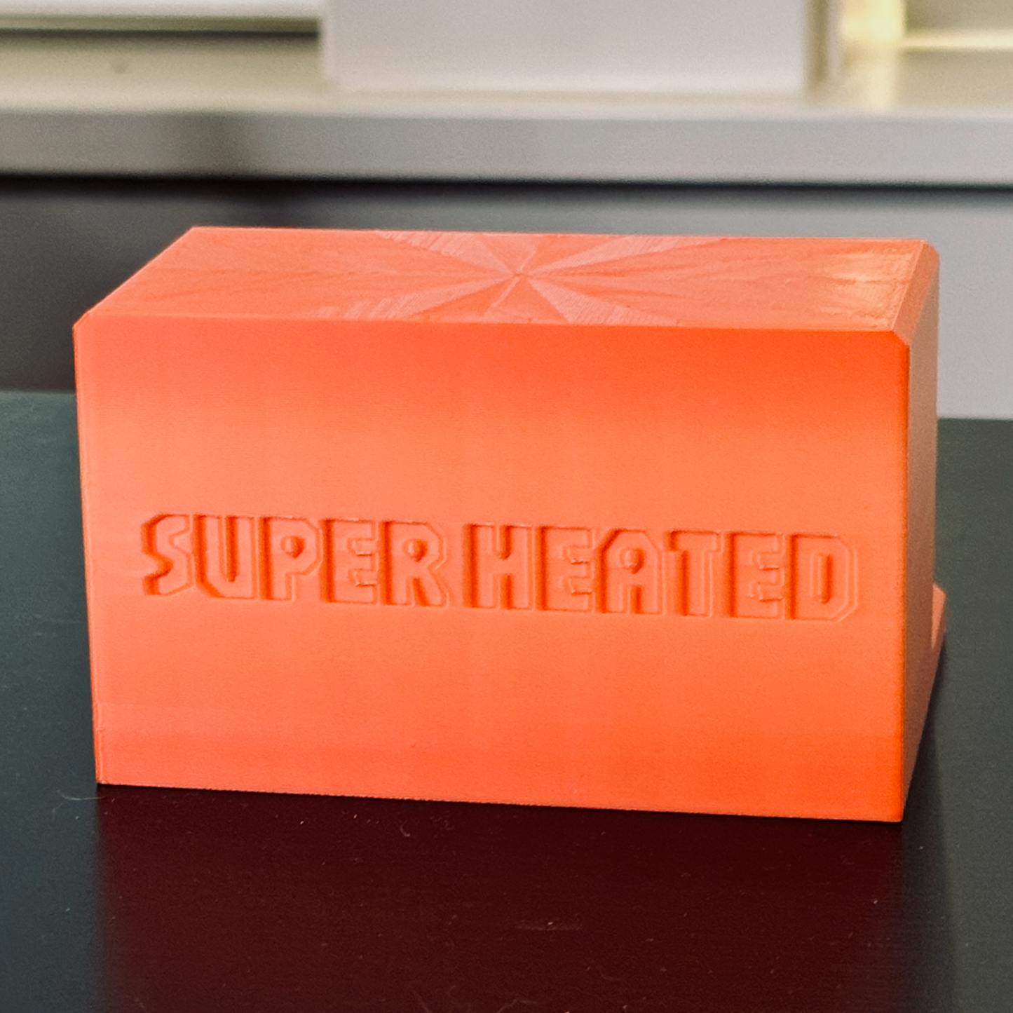 Rear view of the orange record display stand with "Super Heated" embossed in it.