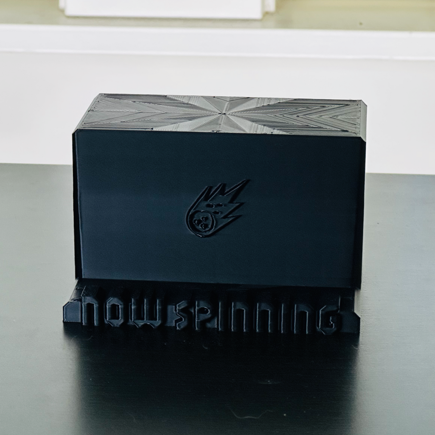 Standalone view of the black "Now Spinning" display stand.