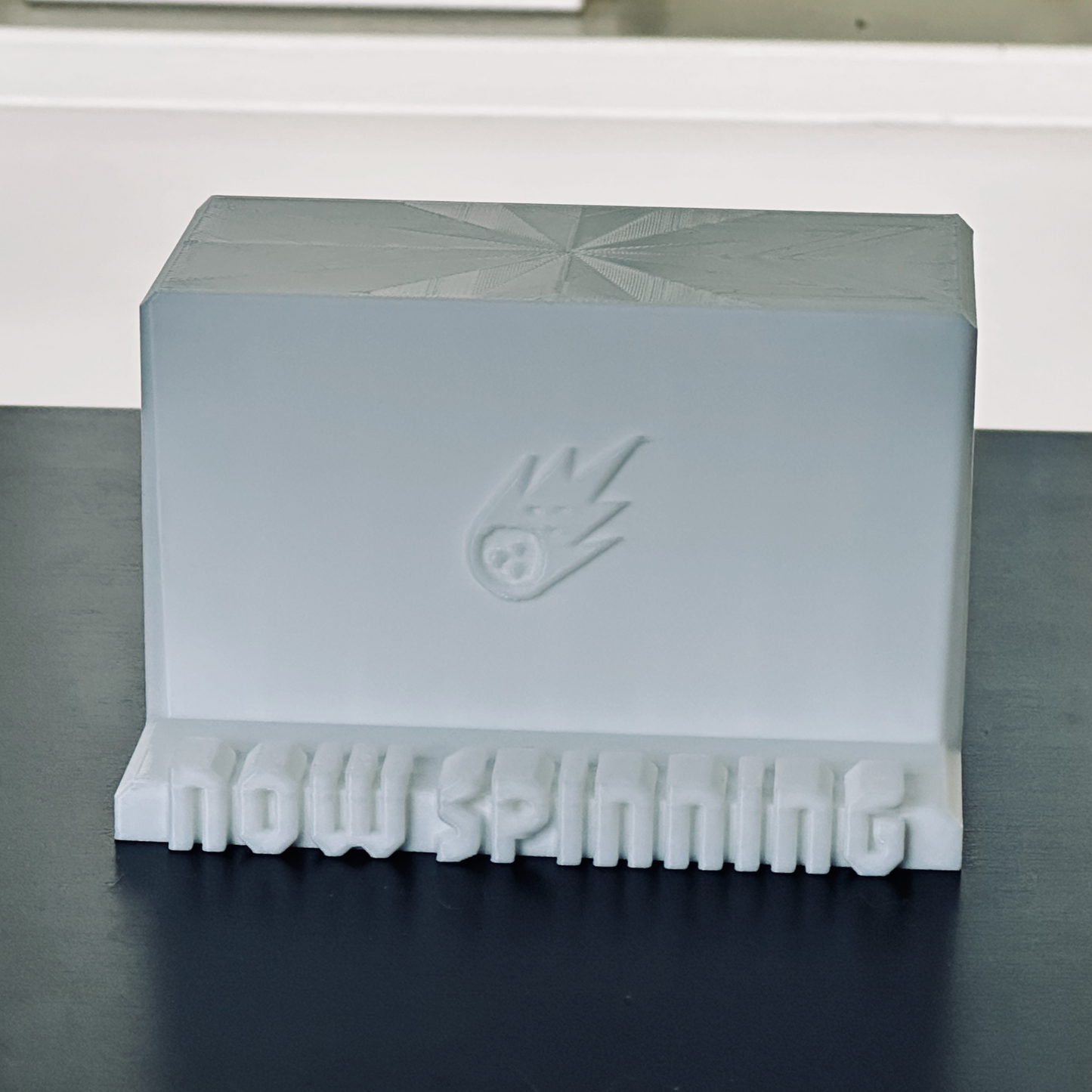 Standalone view of the white "Now Spinning" display stand.